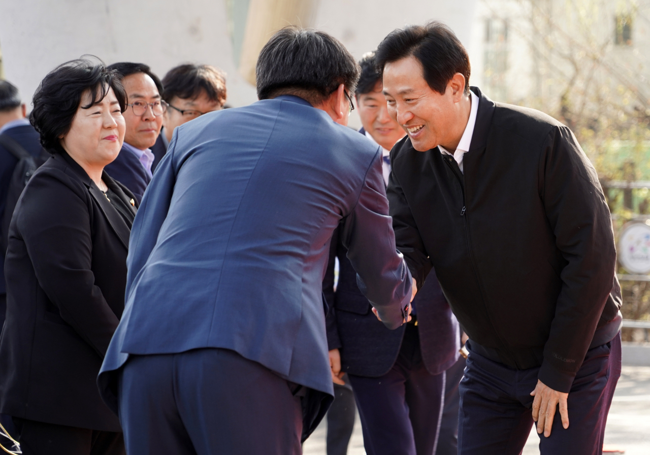 오세훈 서울시장이 지난달 30일 서울 노원구 월계역 공영주차장에서 열린 ‘노원구 송전선로 지중화사업’ 착공식에 참석해 내빈들과 인사하고 있다. [연합]