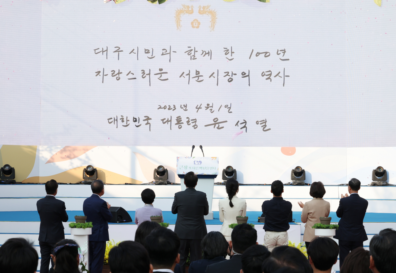 윤석열 대통령과 김건희 여사 1일 대구 서문시장 인근에서 열린 '서문시장 100주년 기념식'에서 기념 퍼포먼스를 한 뒤 영상을 보고 있다. [연합]