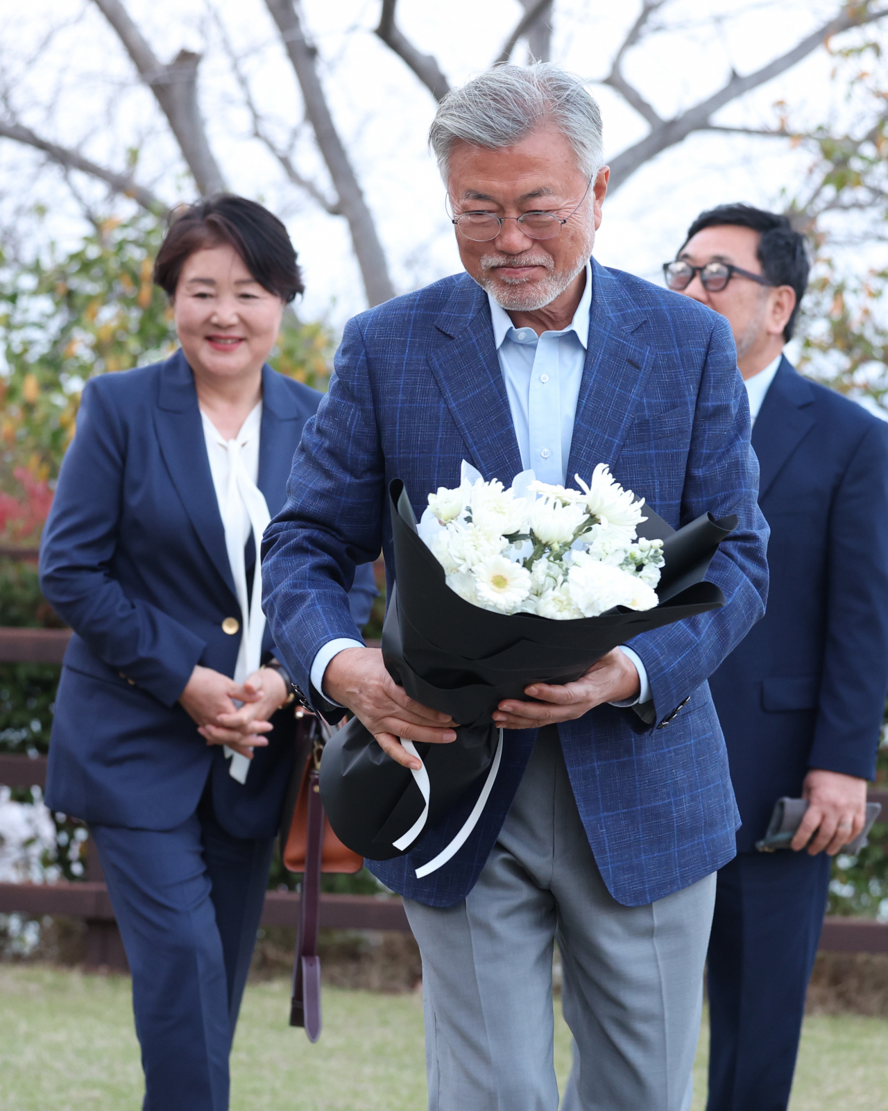 Former South Korean President Moon Jae-in (center) and his wife Kim Jung-sook (left) pay a visit to the late composer Yun I-sang‘s grave, before attending a performance by the Tongyeong Festival Orchestra on the first day of the 21st Tongyeong International Music Festival on Friday. (Yonhap)