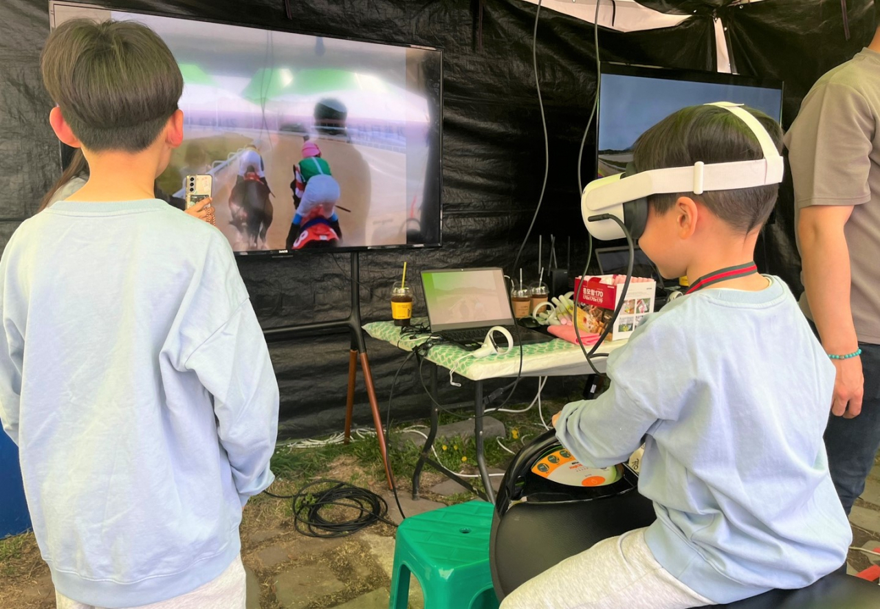 렛츠런파크 부산경남 홍보부스에 방문한 어린이가 VR기기를 이용해 경마체험을 하고 있다. [마사회 제공]