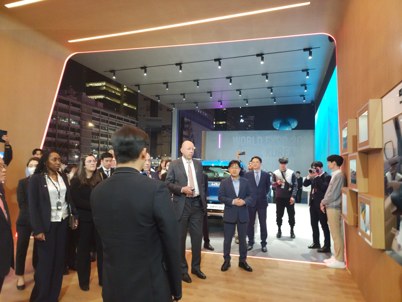 The head of the BIE, Patrick Specht (fourth from left) and members of BIE listen to explanation regarding Kia's ESG efforts in Kia's booth in Gwanghwamun Plaza, Monday. (Lee Yoon-seo/The Korea Herald)