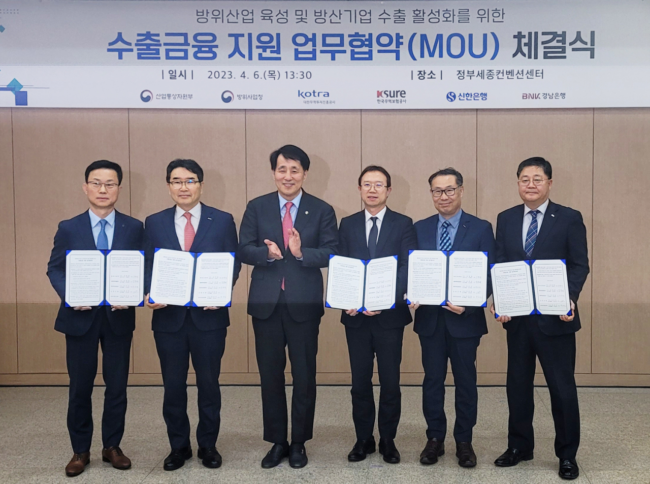 (사진 오른쪽부터)BNK경남은행 박상호 본부장, 코트라 김윤태 부사장, 방위사업청 강환석 차장, 산업통상자원부 장영진 1차관, 한국무역보험공사 윤종배 본부장, 신한은행 김윤홍 부행장이 ‘방산수출 금융지원 업무 협약(MOU)’을 체결하고 있다. [BNK경남은행 제공]