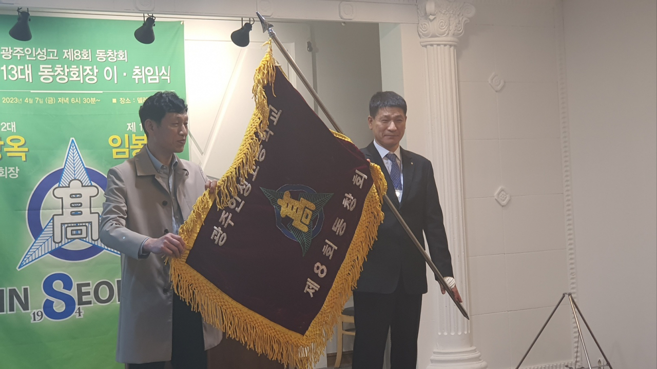 김상옥 전임회장과 임봉혁 신임회장(오른쪽)이 동창회기를 이양하고 있다.