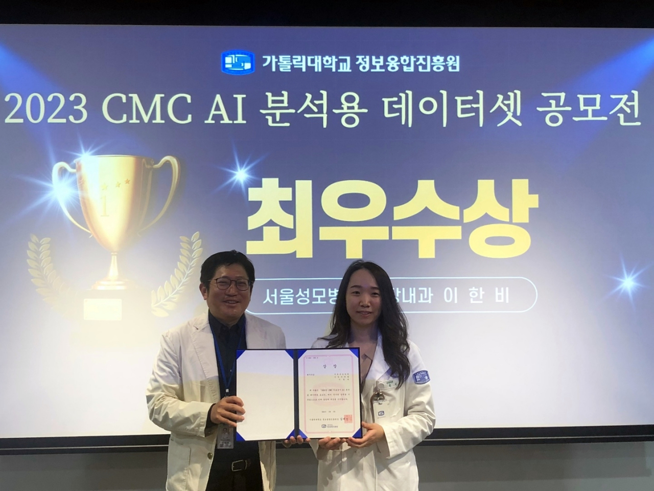 김대진(왼쪽) 가톨릭대 정보융합진흥원장이 3월 31일 열린 ‘2023 CMC(가톨릭대 가톨릭중앙의료원) 의료분야 AI 분석용 데이터셋 공모전’ 시상식에서 최우수상을 수상한 이한비 서울성모병원 신장내과 교수와 기념촬영을 하고 있다. [가톨릭대 정보융합진흥원 제공]