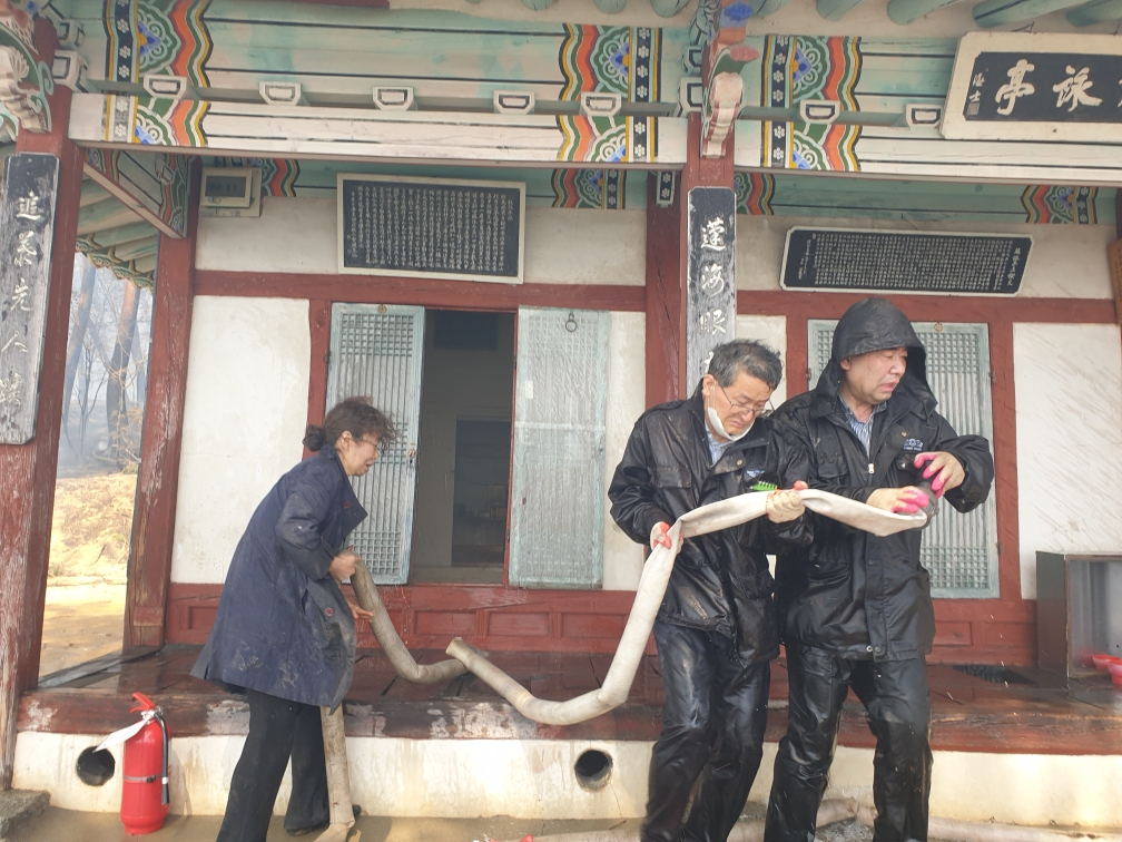 지난 11일 오전 강릉시 저동 ‘방해정(放海亭)’에서 강릉시청 문화유산과 공무원들이 화재 진화 작업을 하고 있다. [강릉시청 제공]