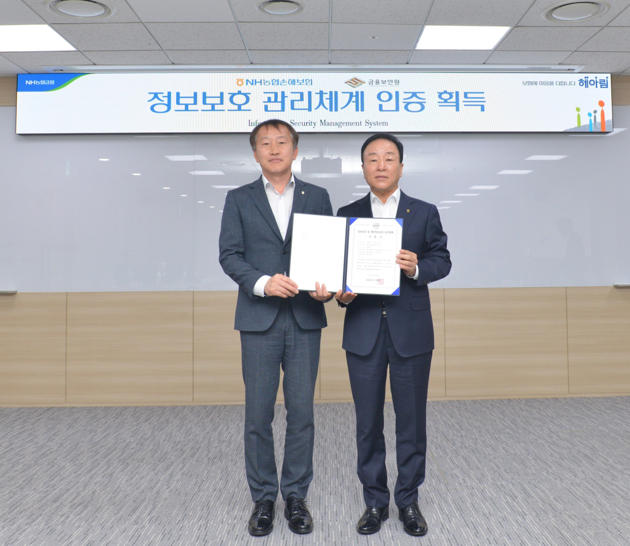 NH농협손해보험(대표 최문섭)은 금융보안원으로부터 ‘대표 홈페이지 및 모바일 웹,앱 서비스 운영’에 대한 정보보호관리체계(ISMS) 인증을 취득했다고 13일 밝혔다. 농협손해보험 최문섭 대표이사(오른쪽)가 기념사진 촬영을 하고 있다. [NH농협손해보험 제공]
