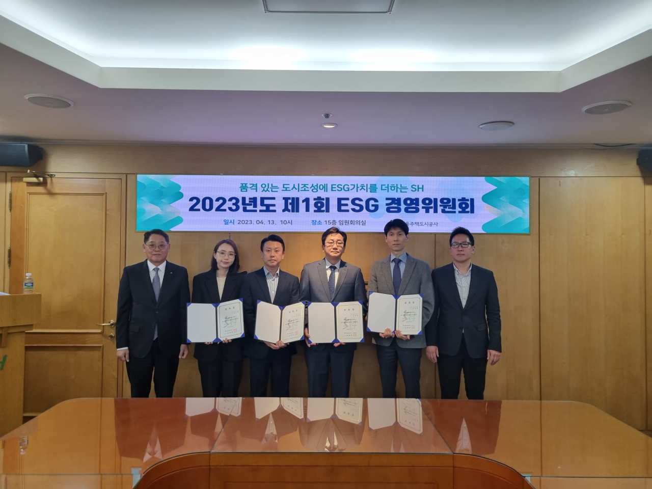 ESG 경영위원들이 위촉장을 들고 포즈를 취하고 있다.