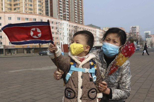 2023년 3월 8일 세계 여성의 날을 맞아 북한 평양에서 한 북한 여성과 아이가 국기를 흔들고 있다. [AP]
