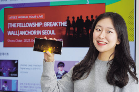 LG유플러스 관계자가 아이돌플러스의 에이티즈 콘서트 소개 페이지와 에이티즈 무대를 소개하고 있다. [LG유플러스 제공]