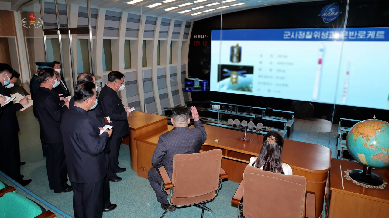 North Korean leader Kim Jong-un (second from right) with his daughter Ju-ae (far right) look at a screen at the National Aerospace Development Administration in Pyongyang, North Korea, on Tuesday. (Yonhap)