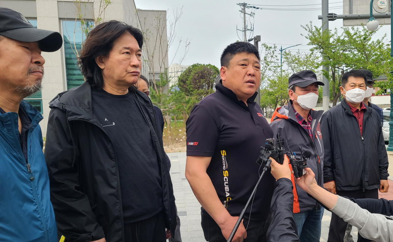 Plaintiffs affected by a wildfire in Goseong, Gangwon Province, speak to the press in front of the Sokcho branch of Chuncheon District Court on Thursday. (Yonhap)