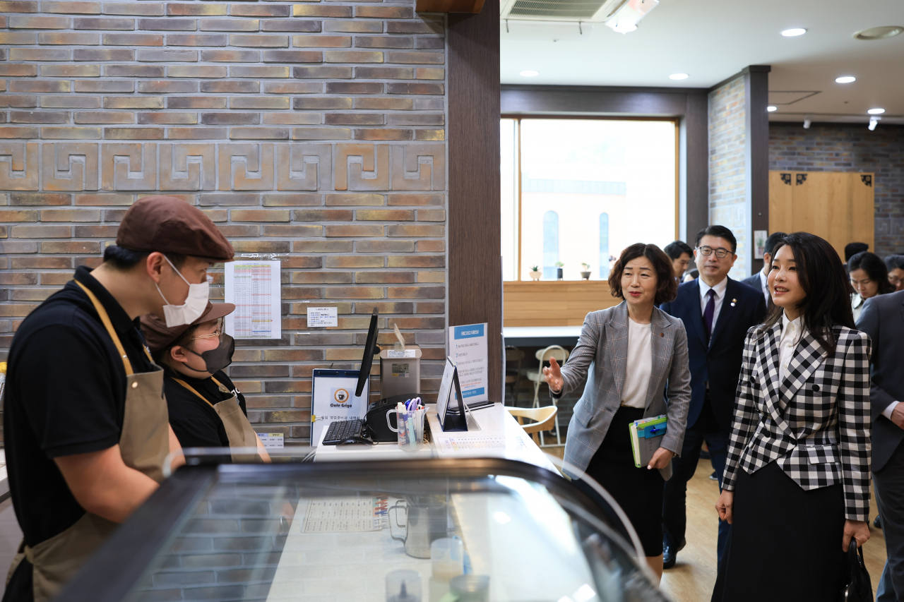 장애인의 날을 맞아 김건희 여사가 20일 인천 남동구 특수학교 미추홀학교를 방문, 교내 카페에서 근무 중인 발달 장애인들과 인사하고 있다. [연합]