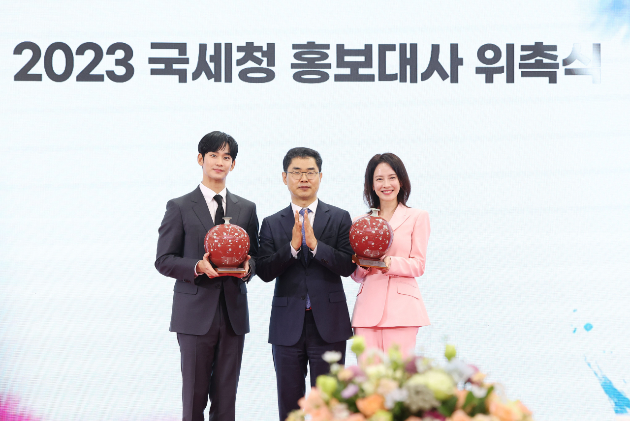 배우 김수현과 송지효가 21일 오전 서울 종로구 서울지방국세청에서 열린 2023년 국세청 홍보대사 위촉식에서 기념품을 들고 김창기 국세청장과 기념촬영을 하고 있다. [연합]