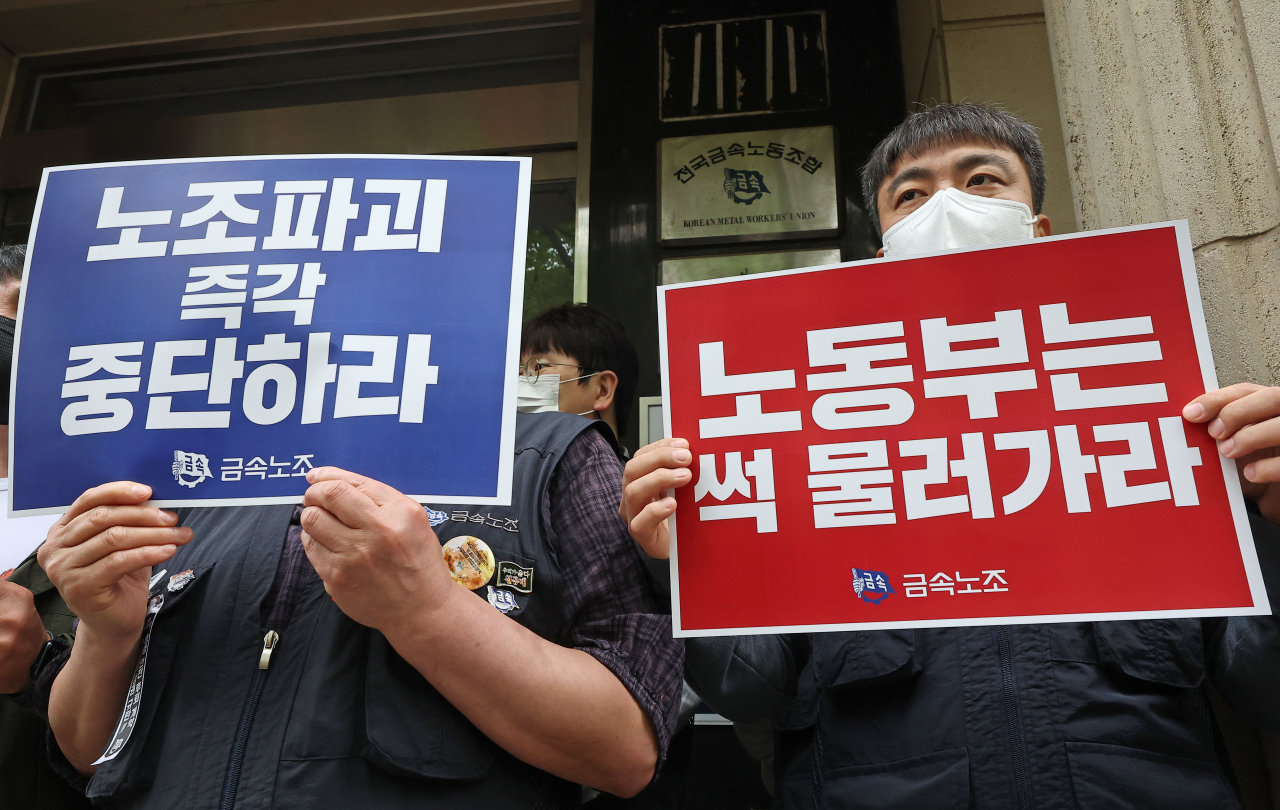 금속노동조합 관계자들이 21일 오전 고용노동부의 회계서류 비치·보존 여부 관련 노조 대상 현장 조사를 앞두고 서울 중구 금속노조 사무실 앞에서 현장 조사 규탄 팻말을 들고 있다. 노동부는 이날부터 민주노총과 그 소속 36개 노조, 한국노총과 그 소속 3개 노조, 미가맹 노조 1개 등 총 42개 노조에 대해 2주간 현장 행정조사를 실시한다. [연합]