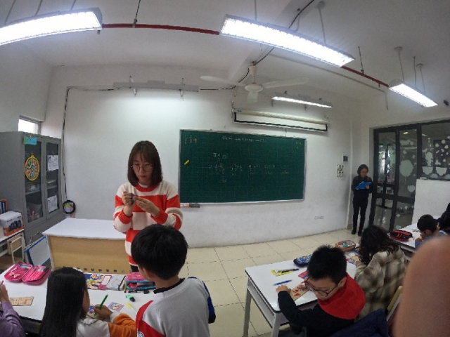 A Korean language teacher and her fifth-grade students make “paengi,” Korean spinning tops, during a class on Feb. 8, 2023. (Choi Jae-hee / The Korea Herald)