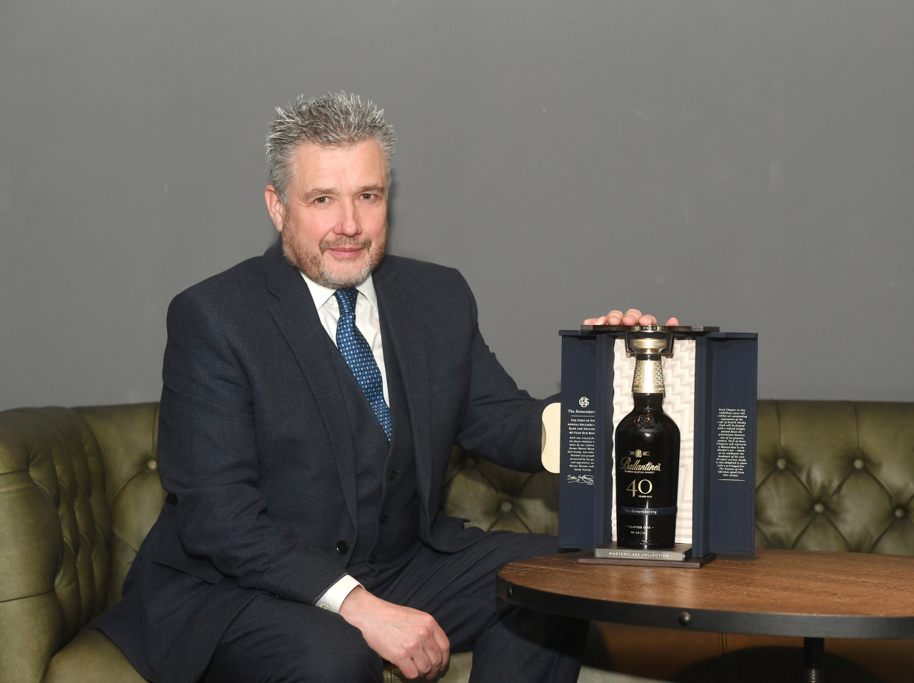 Sandy Hyslop, the master blender at Ballantine’s, poses for a picture next to one of the six bottles of the whisky producer’s new 40-year-old expression, “The Remembering.” (Pernod Ricard Korea)