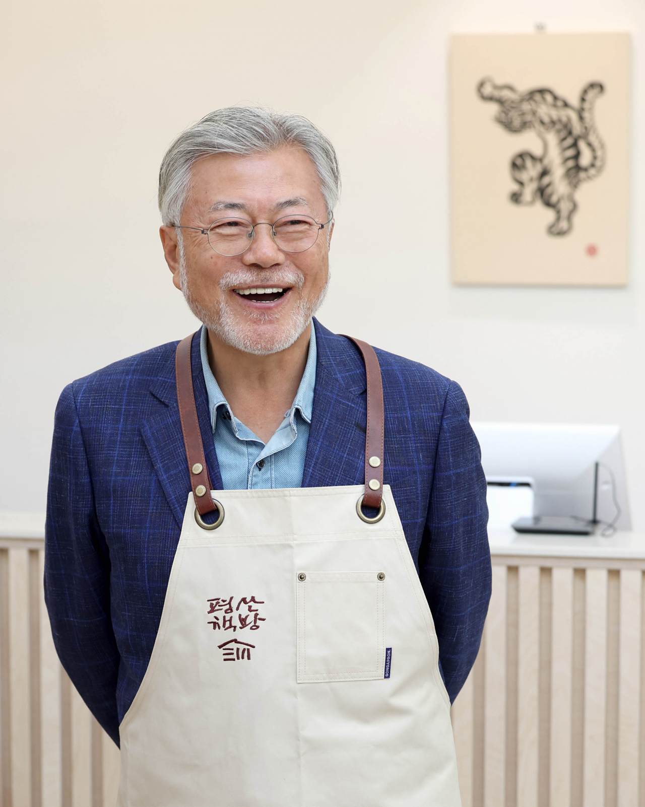 문재인 전 대통령이 26일 오후 경남 양산시 하북면 자신의 책방 '평산책방'에서 앞치마를 착용하며 밝은 표정을 짓고 있다. [연합]