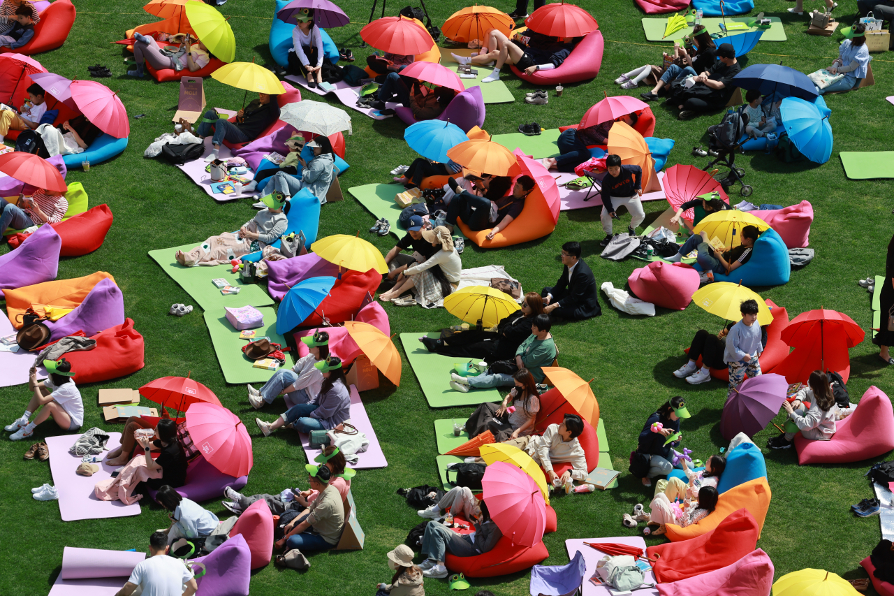Visitors take part in “Reading at Seoul Plaza” on the lawn in front of Seoul City Hall on Sunday. (Yonhap)