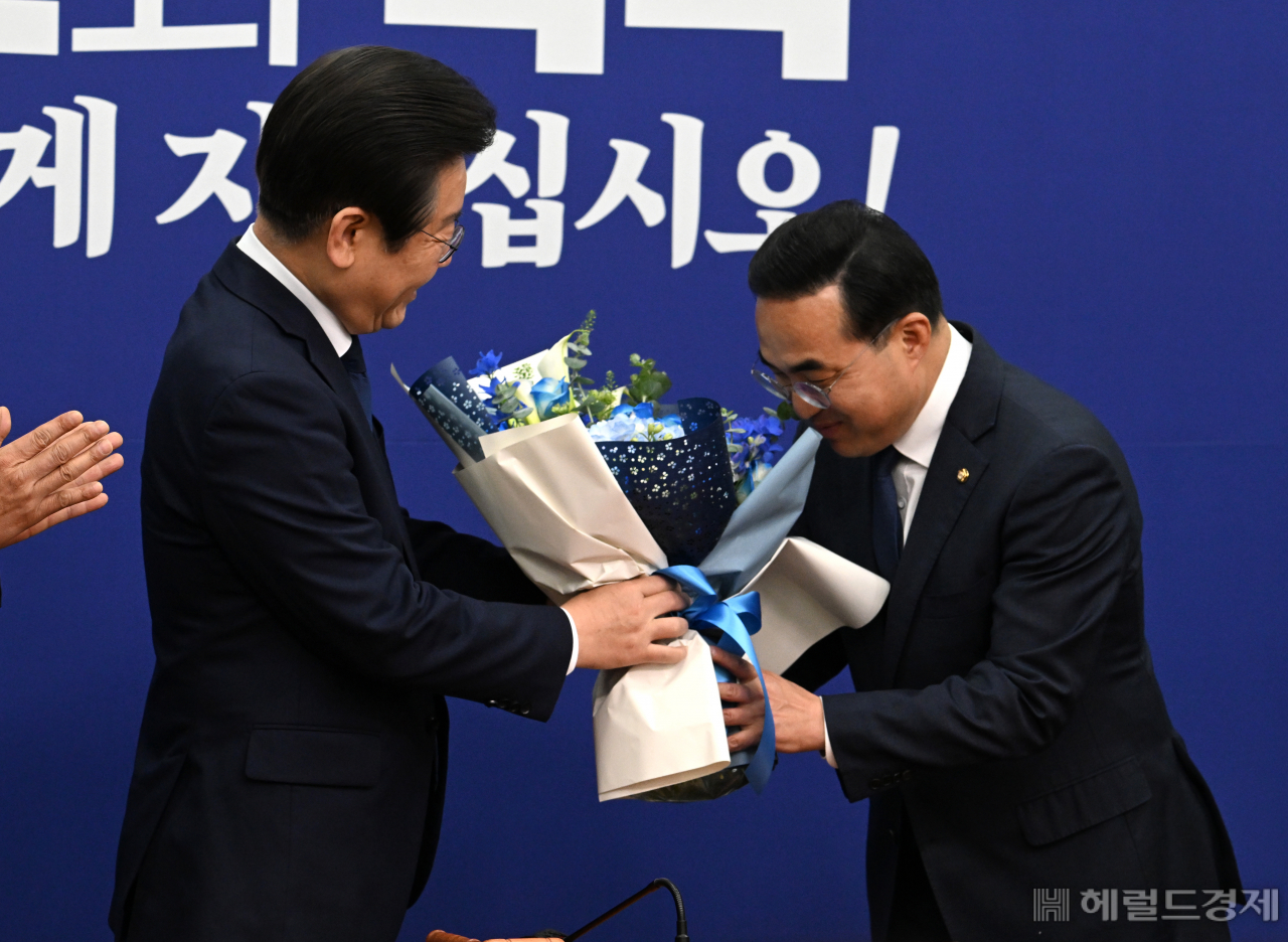 이재명 더불어민주당 당대표가 28일 서울 영등포구 여의도 국회의사당 본청에서 열린 최고위원회의에 참석한 가운데 원내대표에서 물러나는 박홍근 원내대표에게 꽃다발을 전달한 후 함께 기념사진을 촬영하고 있다. 임세준 기자