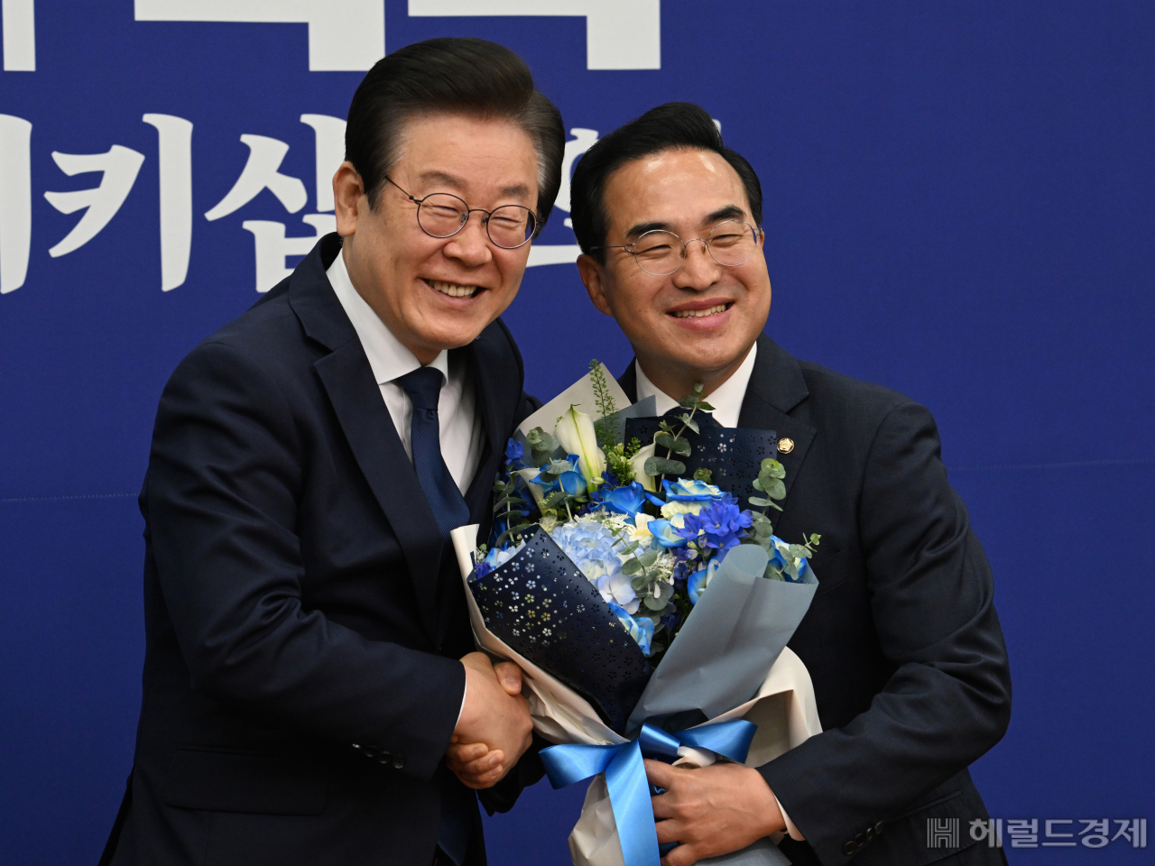 이재명 더불어민주당 당대표가 28일 서울 영등포구 여의도 국회의사당 본청에서 열린 최고위원회의에 참석한 가운데 원내대표에서 물러나는 박홍근 원내대표에게 꽃다발을 전달한 후 함께 기념사진을 촬영하고 있다. 임세준 기자