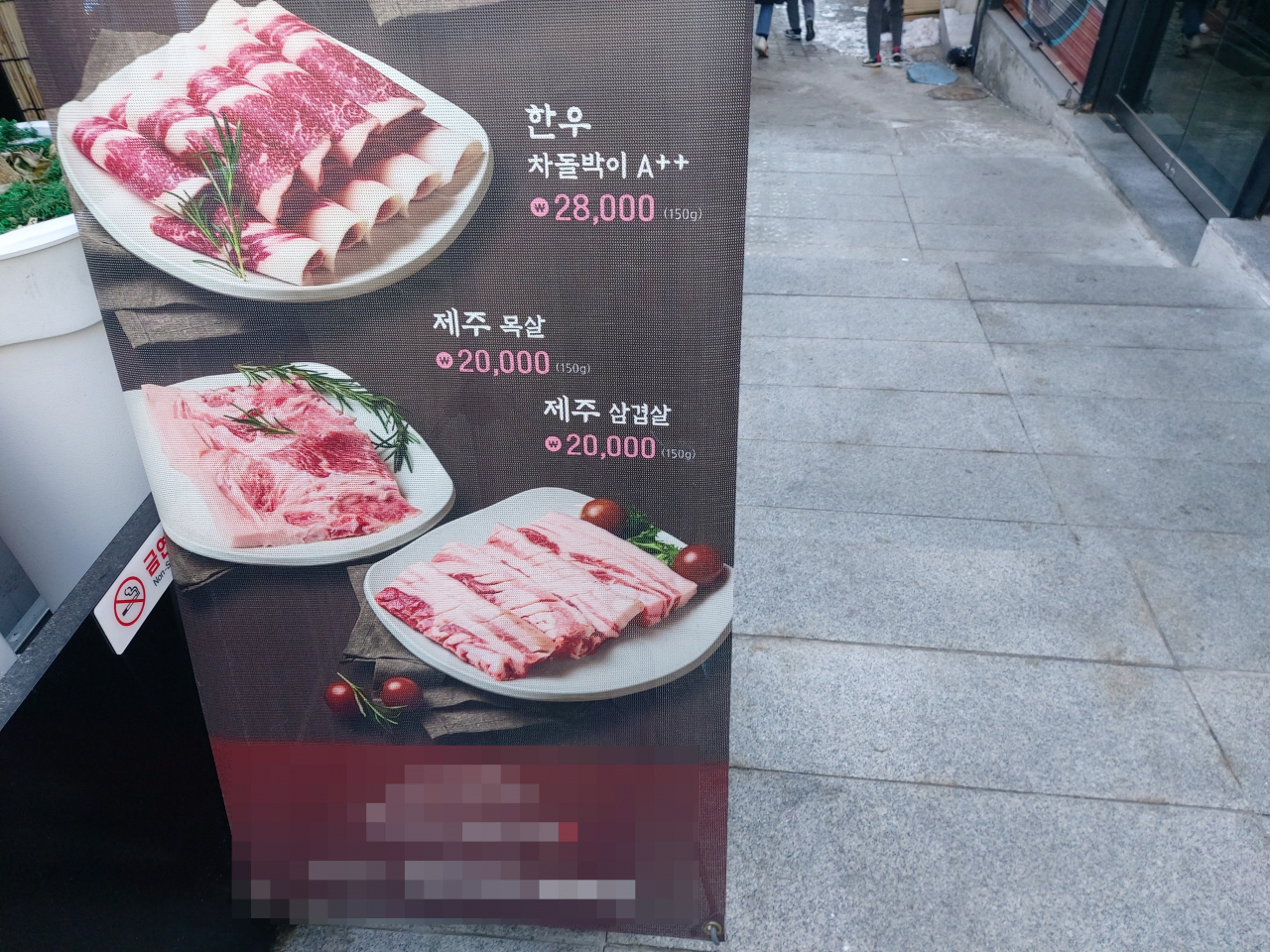 서울 용산구에 위치한 한 삼겹살집의 배너판의 모습. 이 가게의 목살과 삼겹살은 인당 2만원이다. 김희량 기자