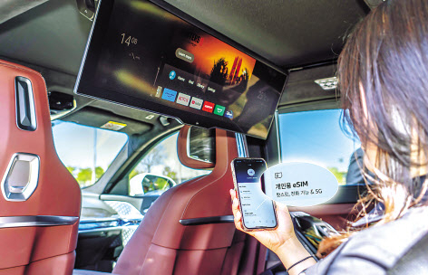 SK텔레콤 모델이 차량용 e심요금제를 활용해 BMW의 뒷자리에서 온라인동영상서비스(OTT)를 선택하고 있다. [SK텔레콤 제공]