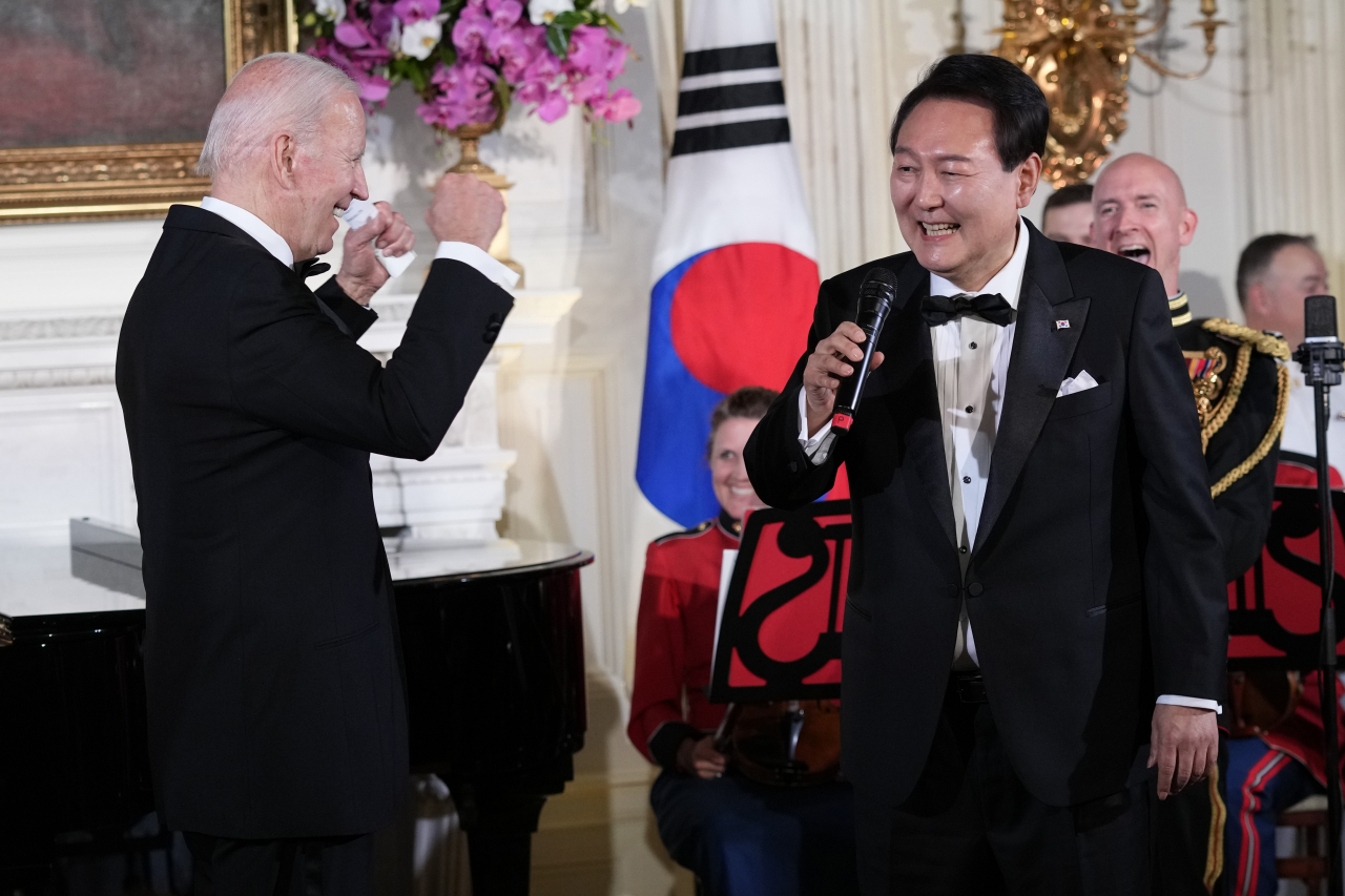 US President Joe Biden reacts as South Korean President Yoon Suk Yeol sings "American Pie" in the State Dining Room of the White House in Washington, last Wednesday, following the state dinner. (AP-Yonhap)