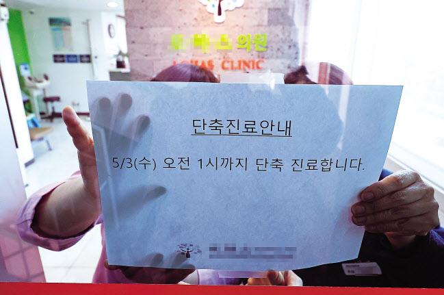 간호법 제정안의 국회 본회의 통과에 반발해 보건복지의료연대가 부분파업에 나선 3일 오전 서울 용산구의 한 동네 의원에서 원장이 입구에 단축 진료 안내문을 붙이고 있다. [연합]