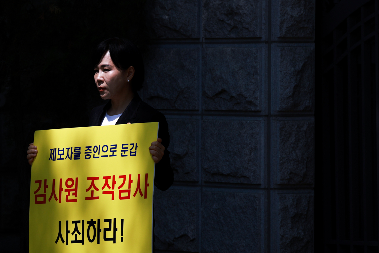 전현희 국민권익위원장이 3일 서울 종로구 감사원에서 권익위 감사와 관련한 본인 입장을 직접 소명하는 '대심'에 출석하기 앞서 팻말 시위를 벌이고 있다. 대심 제도는 사회적 파급효과가 크거나 견해차가 큰 사안에 대해 감사받은 당사자들이 감사위원들에게 본인의 입장을 직접 소명하는 제도다. [연합]