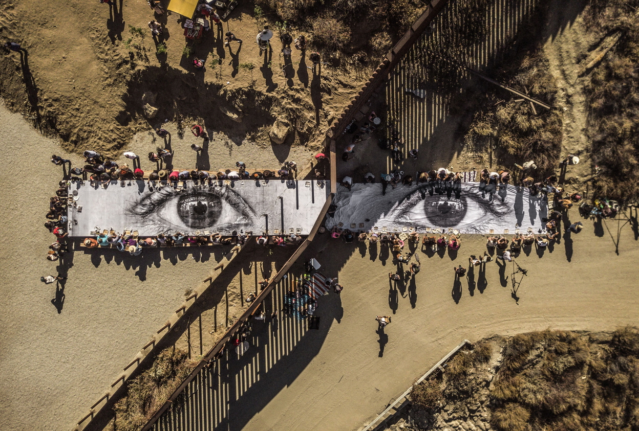 Migrants, Mayra, Picnic across the Border, Tecate, Mexico-U.S.A, Installation image, Wheat-pasted poster on table, 2017. &copy; JR-ART.NET [롯데뮤지엄 제공]