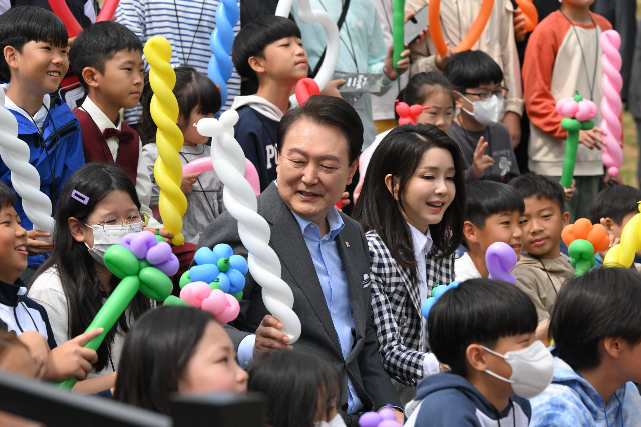윤석열 대통령과 김건희 여사가 4일 서울 용산 대통령실의 앞마당에 조성된 용산 어린이정원 개방행사에서 어린이들에게 풍선을 전달하고 있다. [연합]