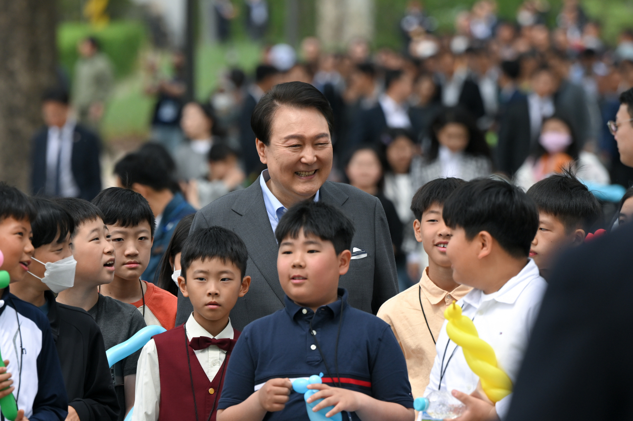 윤석열 대통령이 4일 서울 용산 대통령실의 앞마당에 조성된 용산 어린이정원 개방행사에서 어린이들과 함께 환하게 웃고 있다. [연합]