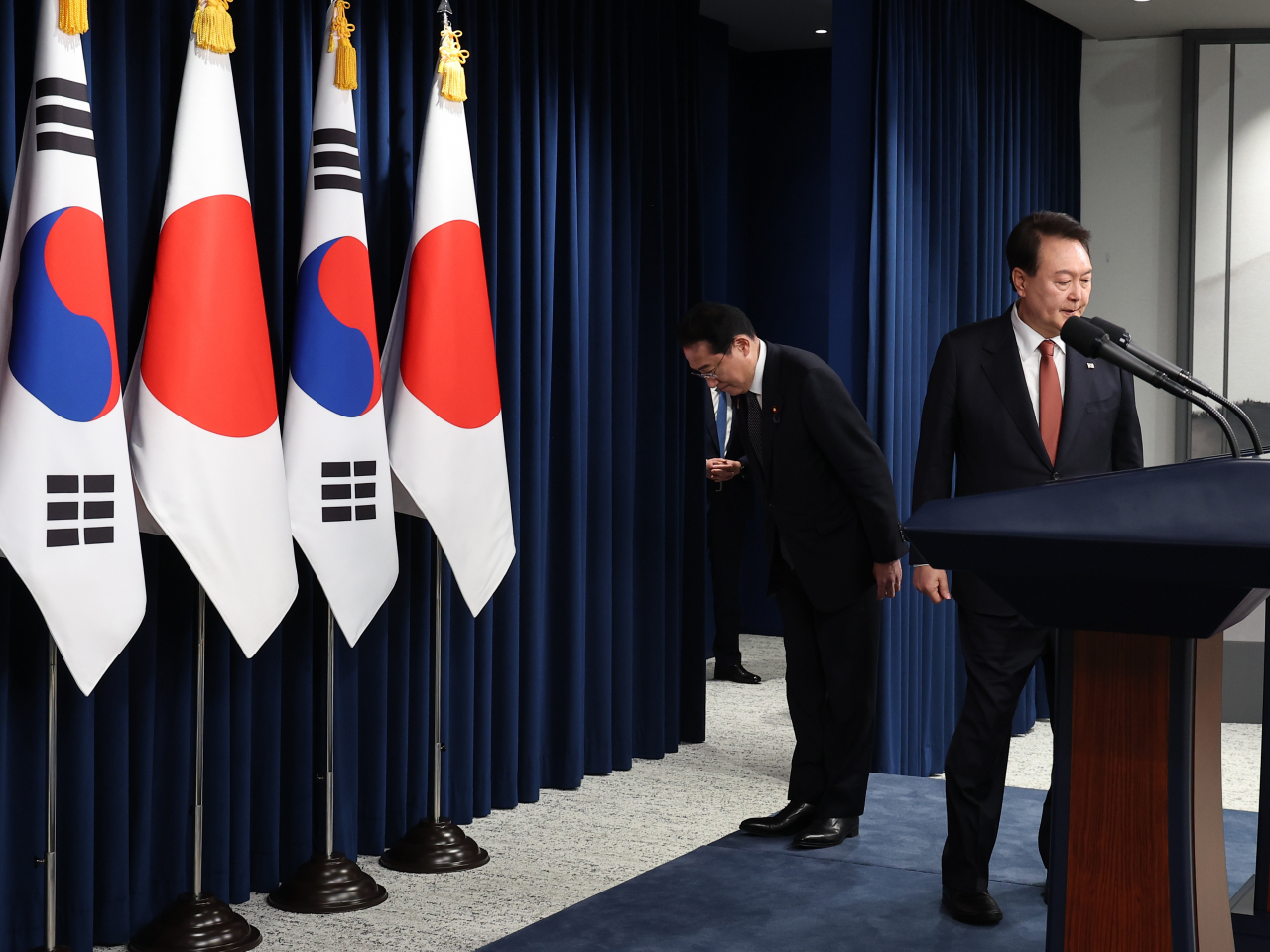 한국을 찾은 기시다 후미오 일본 총리가 7일 서울 용산 대통령실 청사에서 열린 윤석열 대통령과의 공동 기자회견에 입장하며 국기에 예를 표하고 있다. [연합]