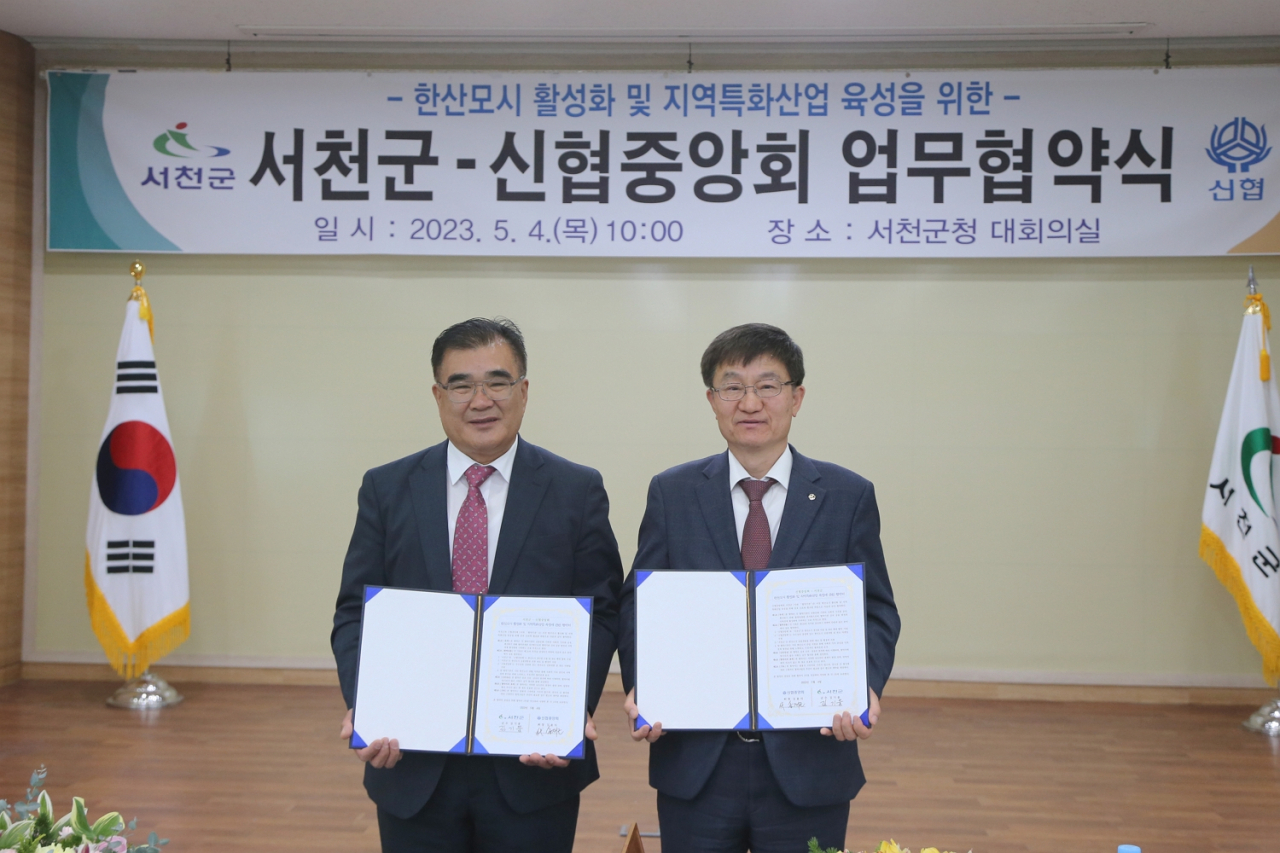 4일 서천군청에서 진행된 ‘한산모시 활성화 및 지역특화산업 육성에 관한 업무협약식’에 참석한 김기웅 서천군수(왼쪽)와 송재근 신협중앙회 사업 대표이사가 기념촬영을 하고 있다. [사진=신협중앙회]