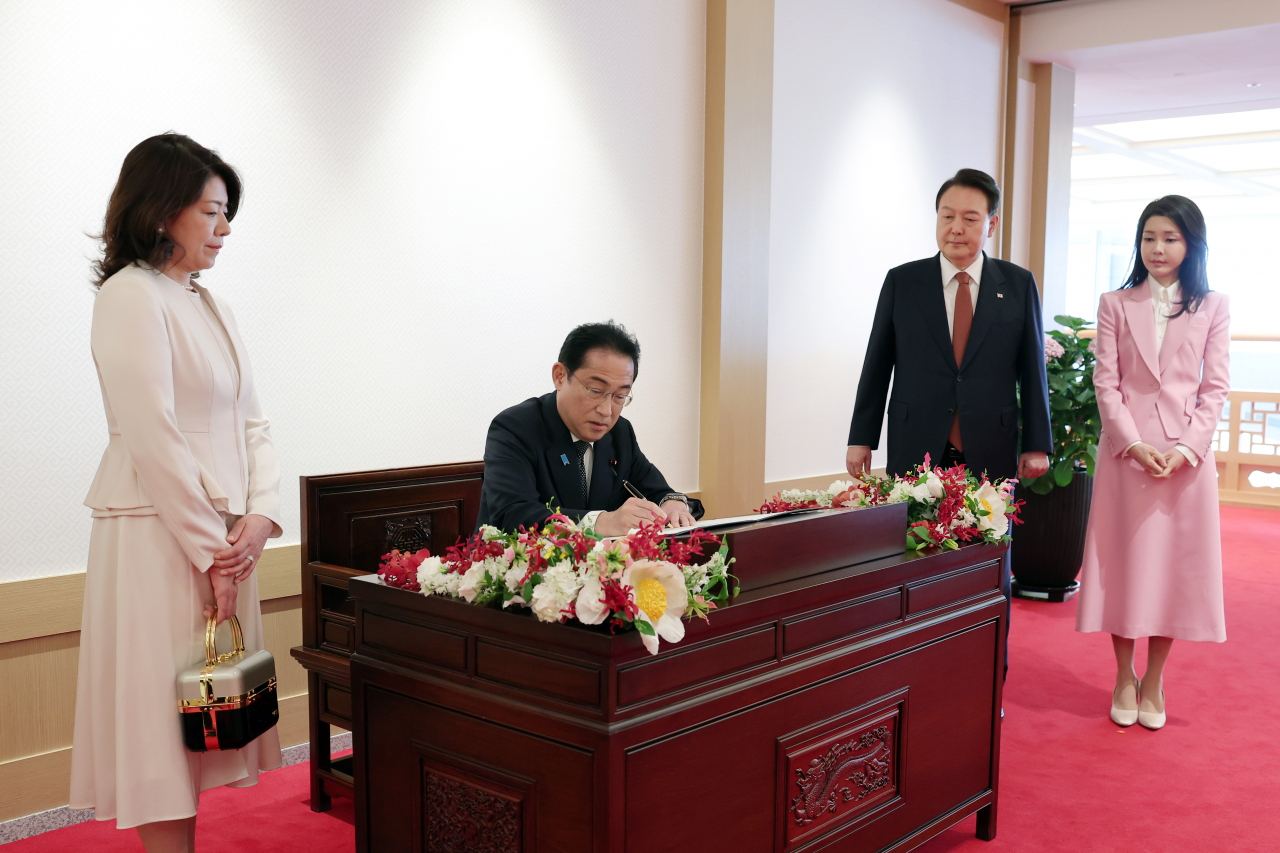 기시다 후미오 일본 총리가 7일 서울 용산 대통령실 청사에서 한일 정상회담에 앞서 윤석열 대통령과 김건희 여사가 지켜보는 가운데 방명록에 서명하고 있다. 연합뉴스