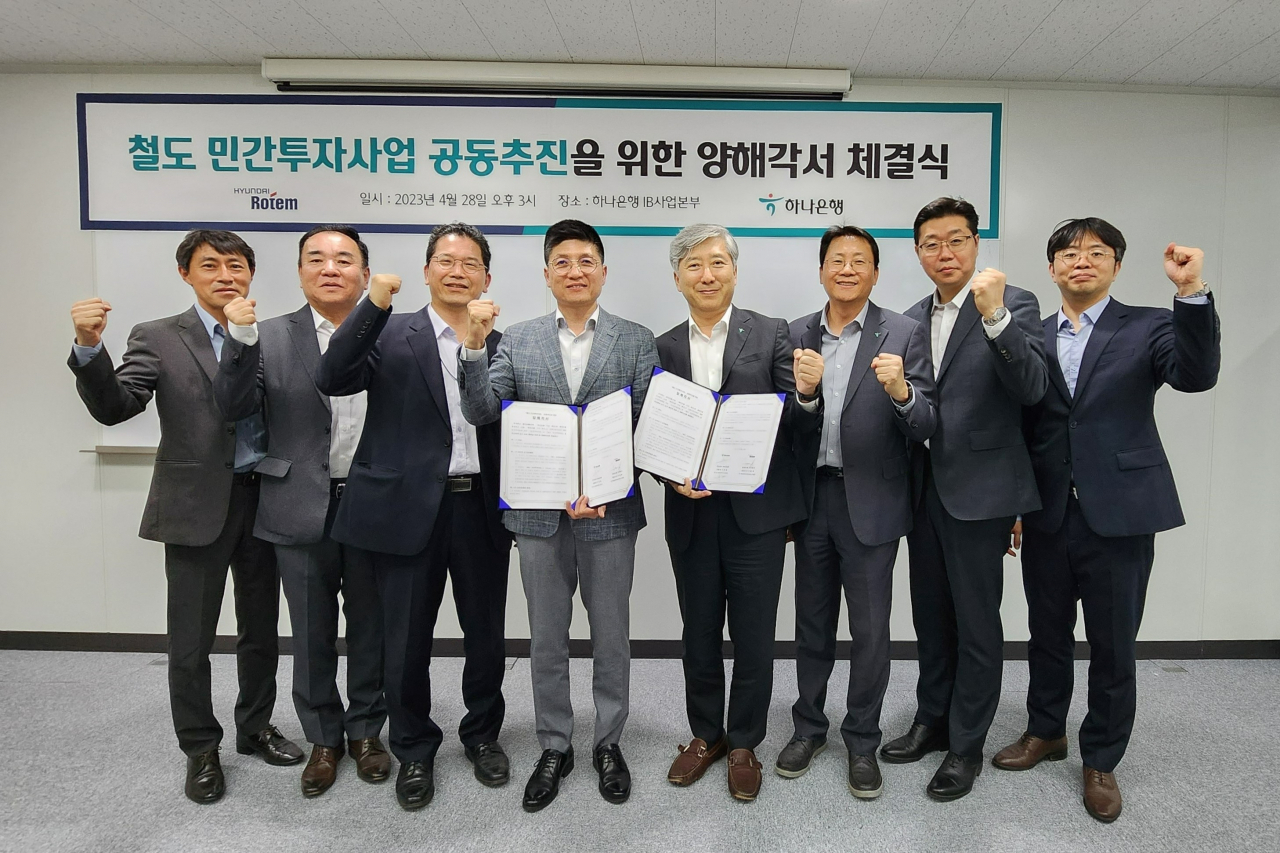 김정훈(왼쪽 네번째) 현대로템 레일솔루션본부장과 전호진(왼쪽 다섯번째) 하나은행 IB사업본부장이 MOU 체결 후 기념촬영을 하고 있다. [현대로템 제공]