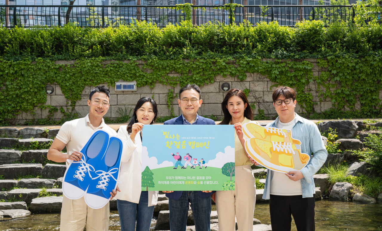지난달 27일 서울시 종로구 청계천에서 신한라이프의 '빛나는한걸음' 캠페인에 참여한 직원들이 기념촬영을 하고 있다. [신한라이프 제공]