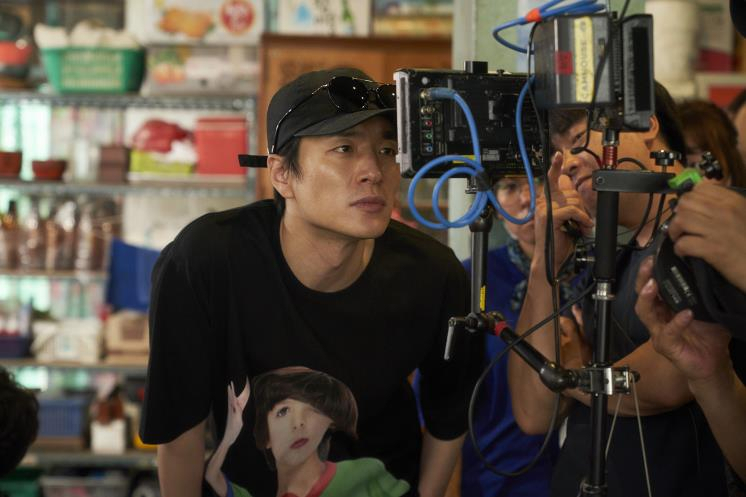 Director Lee Byeong-heon looks into the monitor while shooting for "Extreme Job." (CJ Entertainment)