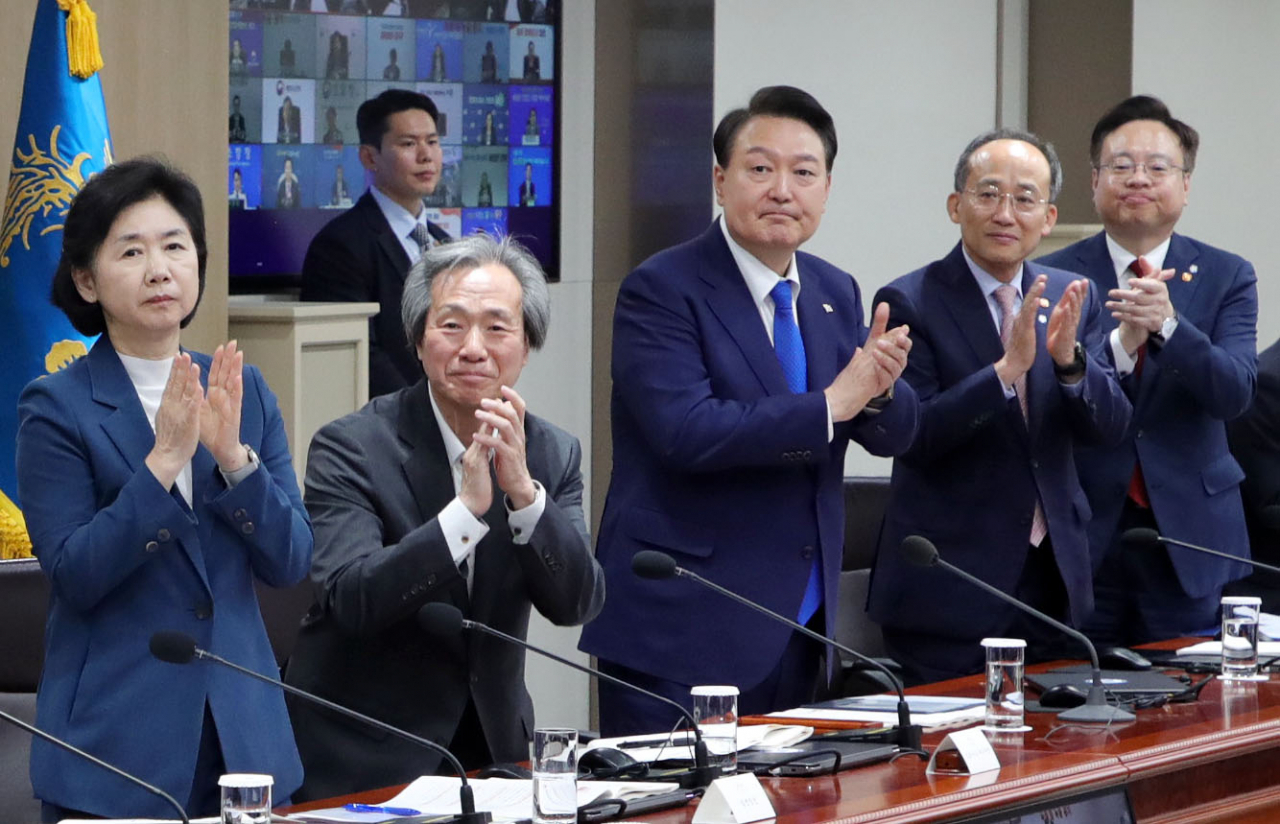 윤석열 대통령과 중대본 위원들이 11일 서울 용산 대통령실 청사에서 열린 코로나19 중앙재난안전대책본부 회의에서 코로나19 방역 최전선에서 활약한 의사, 간호사, 간호조무사 등 보건 의료진에게 격려의 박수를 보내고 있다. [연합]