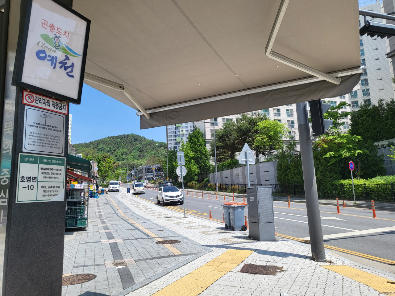 8일 오전 경상북도 예천 호명면 검무로(路)에 예천군이 설치한 횡단보도 그늘막이 펼쳐져 있다. 길 건너 아파트는 행정구역상 안동시 풍천면에 속한다. 김진 기자
