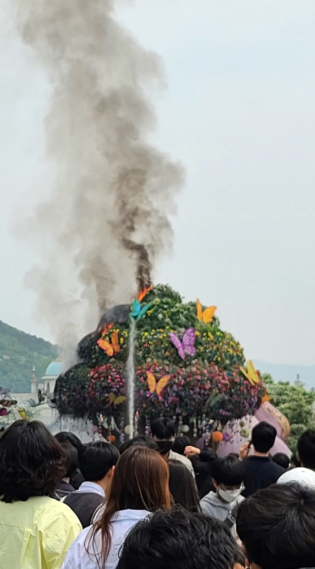 12일 오전 경기 용인시 에버랜드 정문 앞 광장에 설치된 높이 13ｍ의 조형물 '매직트리'에서 불이 나 연기가 치솟고 있다. 불은 인명피해 없이 출동한 소방관들에 의해 20여 분만에 꺼졌다. [연합]