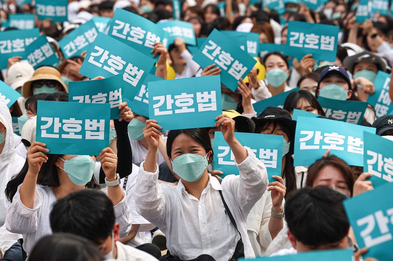 국제 간호사의 날인 12일 오후 간호사들이 서울 종로구 광화문 일대에서 열린 '2023 국제간호사의 날 기념 축하 한마당' 행사에서 밝은 표정으로 팻말을 흔들고 있다. 연합뉴스