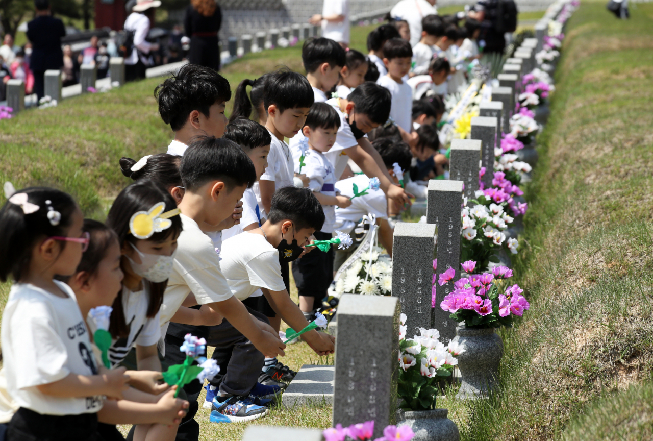 5·18 민주화운동 43주년을 이틀 앞둔 16일 광주 북 구 운정동 국립 5·18민주묘지에서 아이들이 헌화하고 있다. 연합뉴스