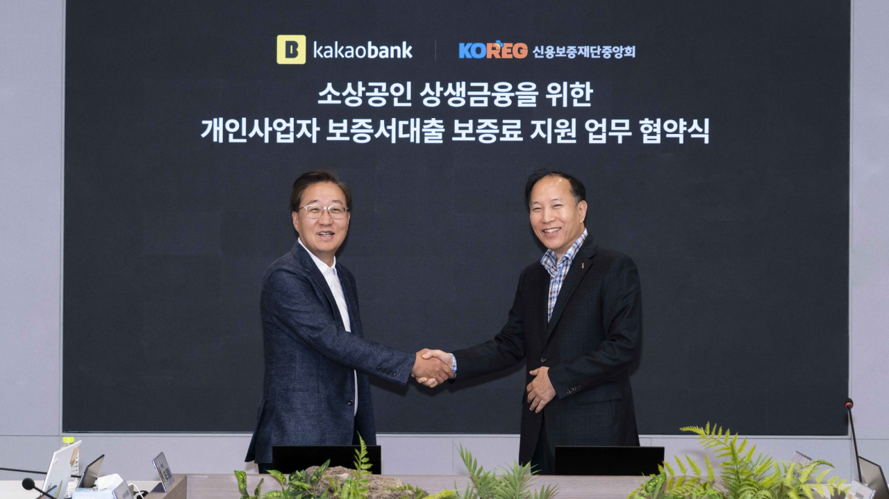 윤호영 카카오뱅크 대표(왼쪽)와 신용보증재단중앙회 이상훈 회장이 지난 16일 카카오뱅크 판교오피스에서 진행된 '소상공인 상생금융을 위한 보증료 지원 업무 협약 체결식'에서 기념 촬영을 하고 있다. [카카오뱅크 제공]