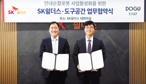 김윤호(오른쪽) SK쉴더스 성장추진실장과 김진효 도구공간 대표가 16일 안내순찰로봇 사업 협력을 위한 업무협약을 체결한 뒤 기념촬영을 하고 있다. [SK쉴더스 제공]