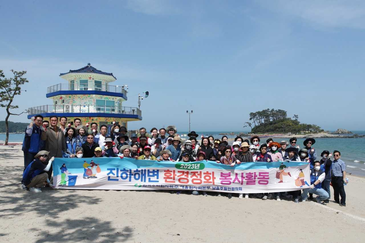 새울원자력본부 신입직원들이 17일 울산 울주군 진하해수욕장에서 지역주민과 함께 해안정화 봉사활동인 ‘비치코밍’을 진행하고 있다. [사진=새울원자력본부]