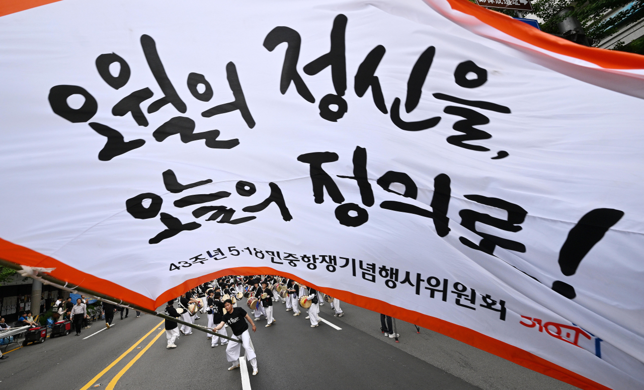 17일 오후 광주 동구 금남로에서 5·18 민주화운동 43주년 전야제가 열려 대형 깃발을 든 풍물패가 행진 대열을 이끌고 있다. 연합뉴스