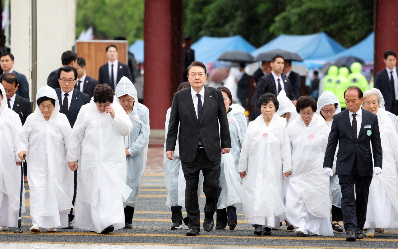 윤석열 대통령이 18일 광주 북구 국립5·18민주묘지에서 열린 제43주년 5·18민주화운동 기념식에 오월어머니회 회원들과 함께 입장하고 있다. [연합]