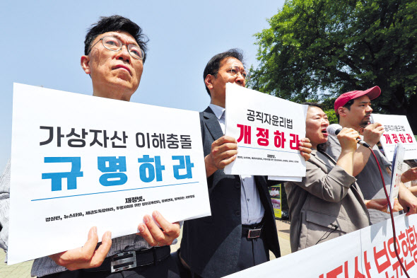 경제정의실천시민연합, 참여연대 등 6개 단체가 속한 ‘재산공개와 정보공개 제도개선 네트워크’ 관계자들이 16일 오전 서울 여의도 국회 앞에서 고위공직자 가상자산 보유현황 전수조사, 가상자산을 등록대상재산에 포함하는 공직자윤리법 개정 등을 촉구하며 손팻말을 들고 있다. [연합]