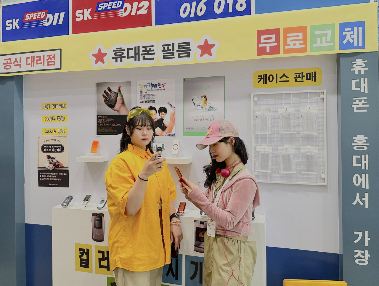 모델들이 2000년대 홍대 거리를 담은 V컬러링 팝업존을 체험하는 모습. [SK텔레콤 제공]